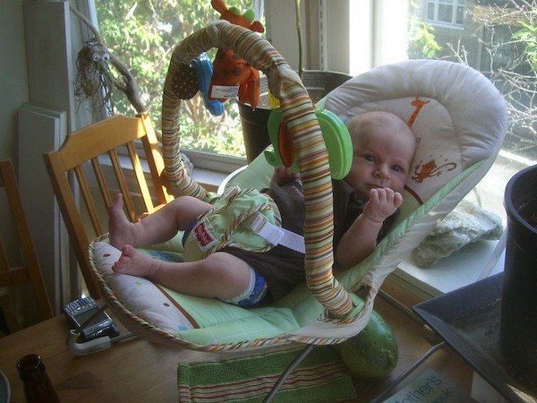 Baby in a bouncer on table