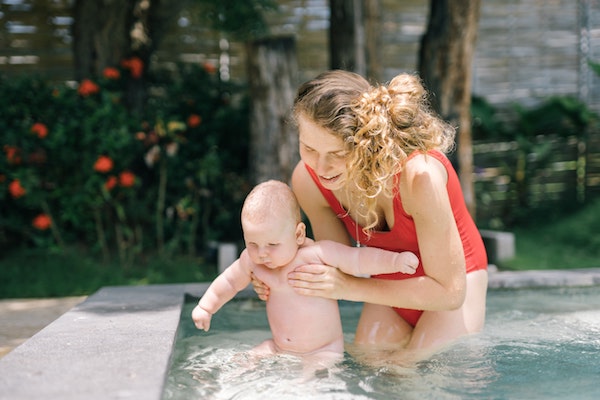 Baby and mom in backyard pool