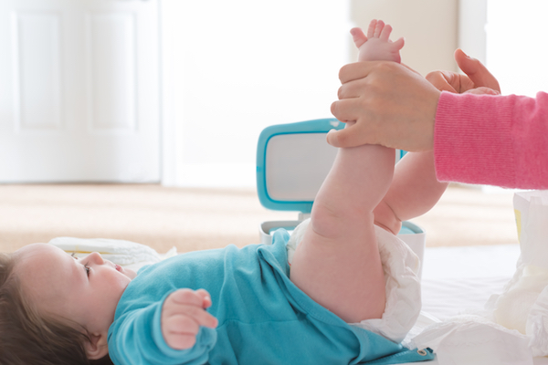 Baby boy getting his diaper changed by mom
