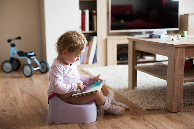 Girl sitting on training toilet